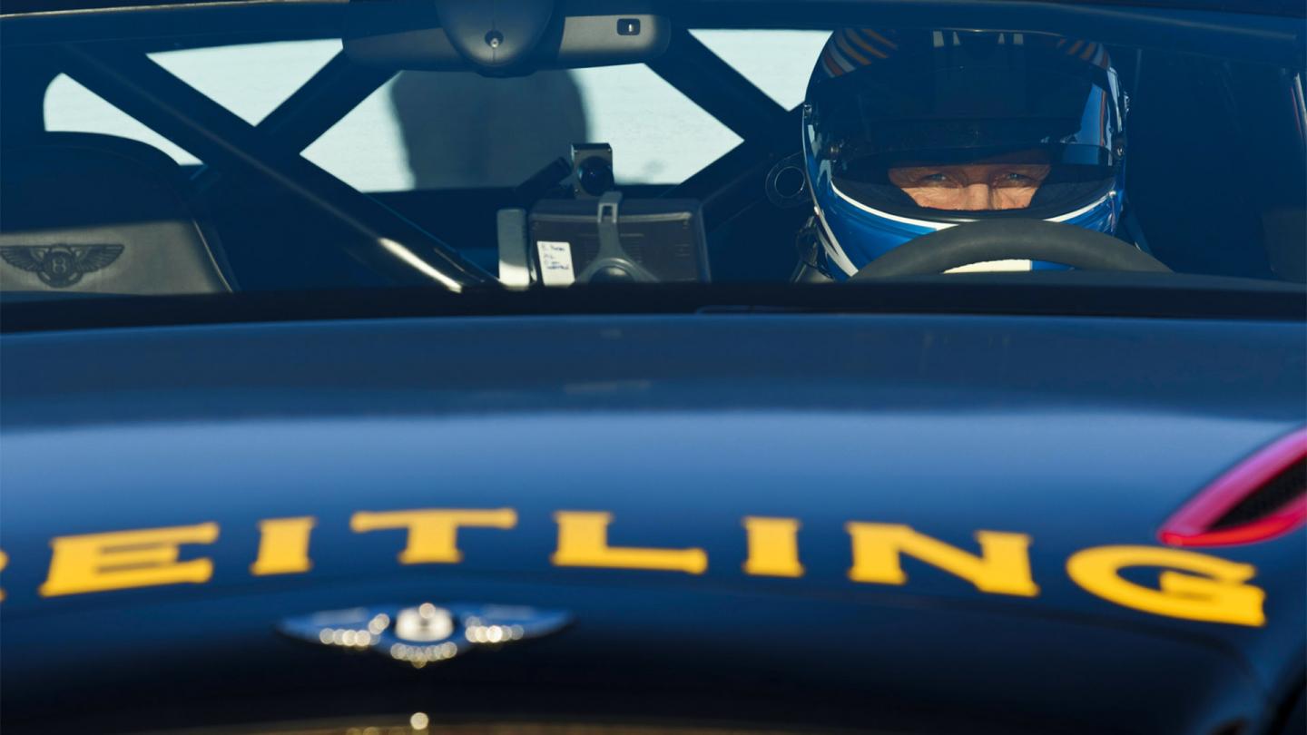 Juha Kankkunen staring into the lense of a camera as he sits in the drivers seat of the record setting Bentley Continental GT