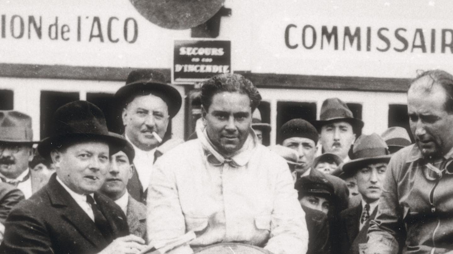 Woolf Barnato sat on his race winning Bentley alongside his co-driver in the Le Mans pits