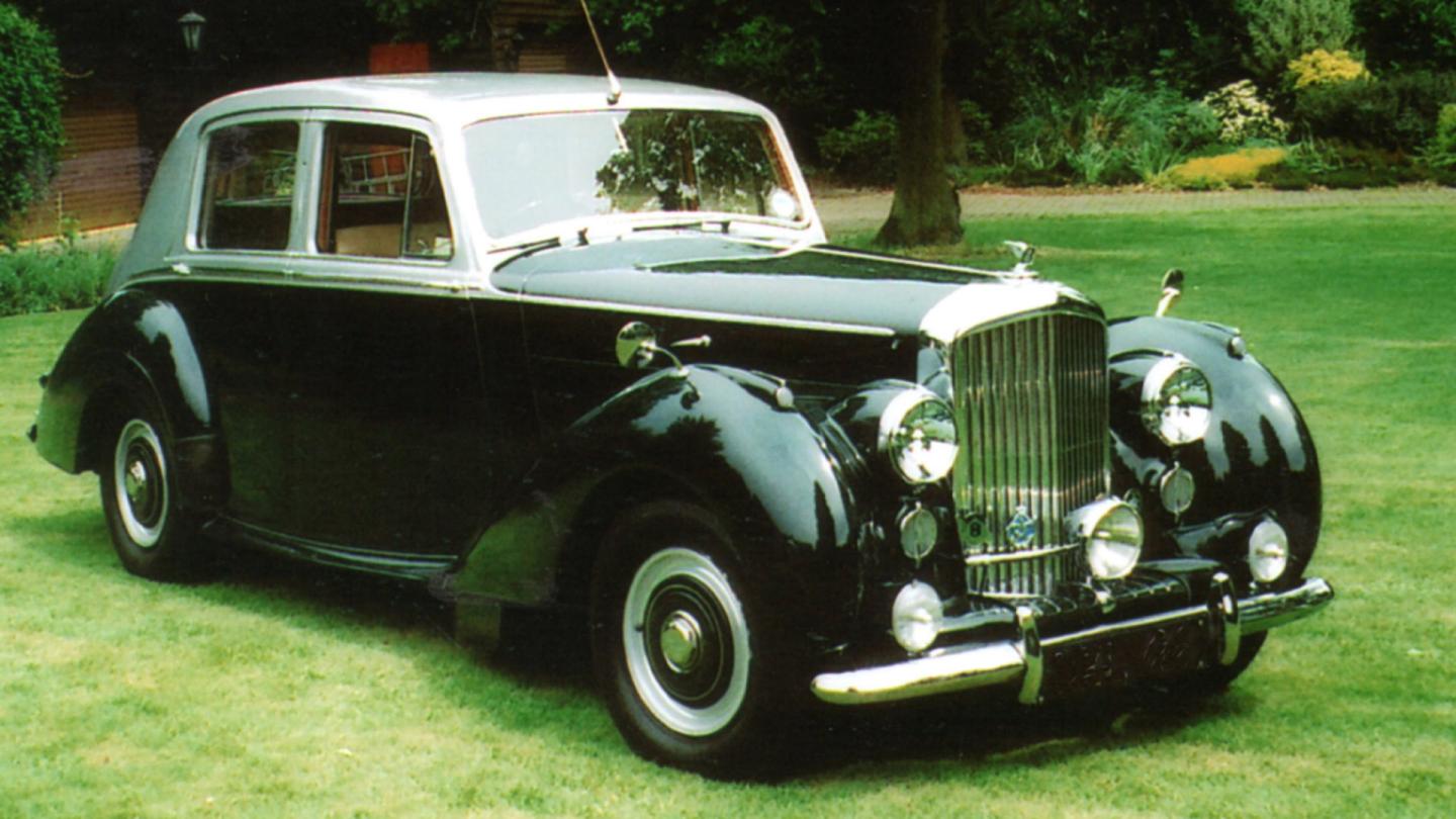 Front three quarter of a duo tone Bentley R Type parked on a lawn