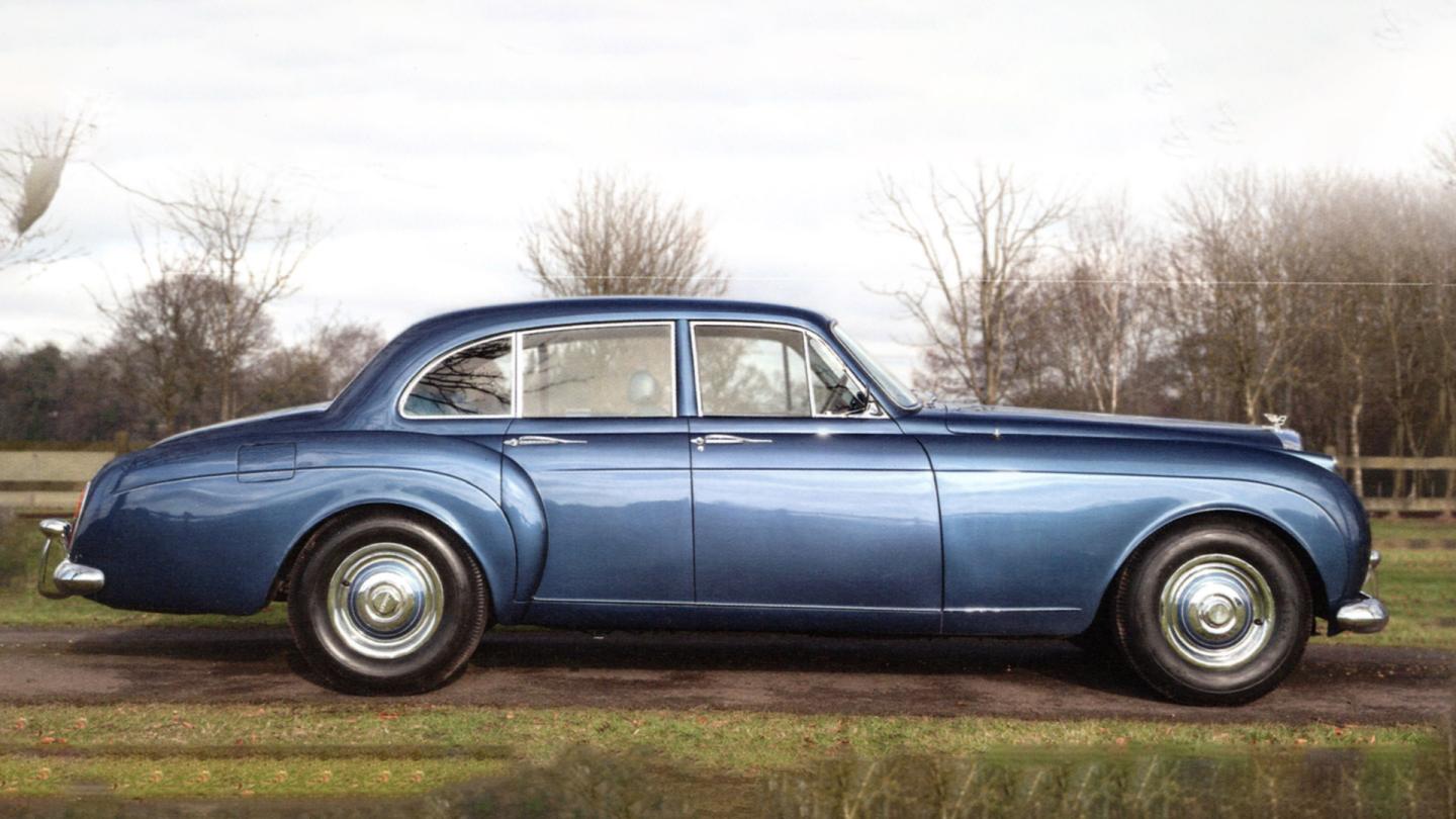 A side profile of a S1 Continental Flying Spur with a blue exterior colour and steel wheels