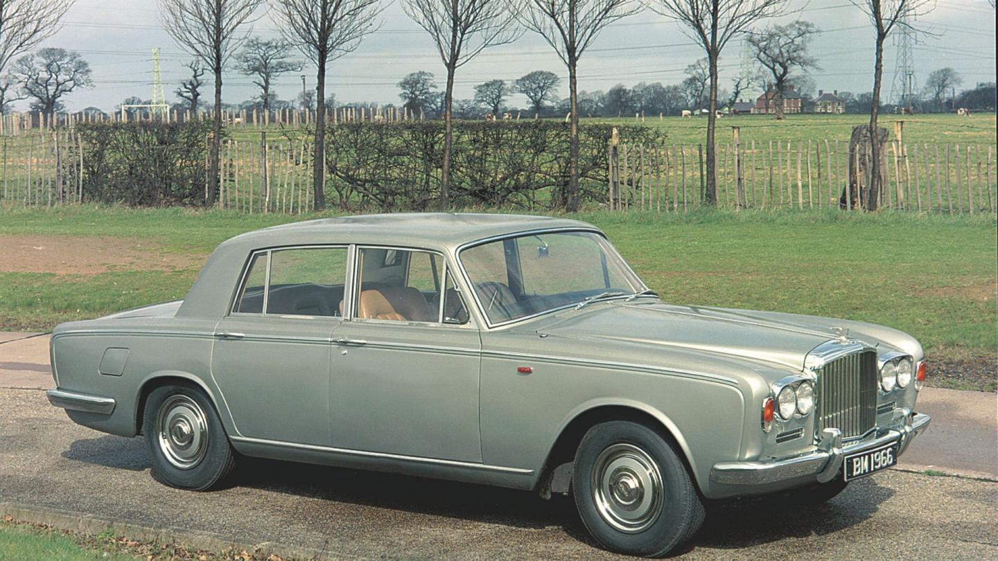 Side profile of a green single tone Bentley T-Series in a rural environment