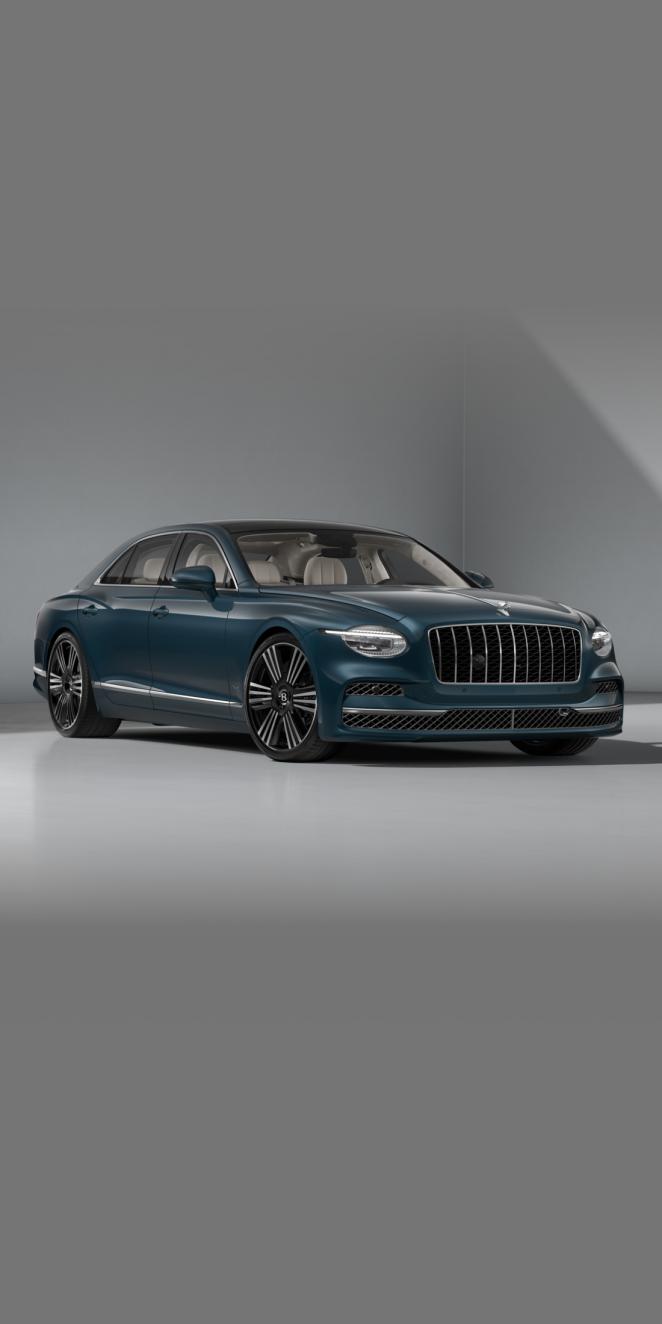 Front three-quarter of the Bentley Flying Spur Azure in Dark Teal showing the headlights and 22" Azure Black & Machined wheel.