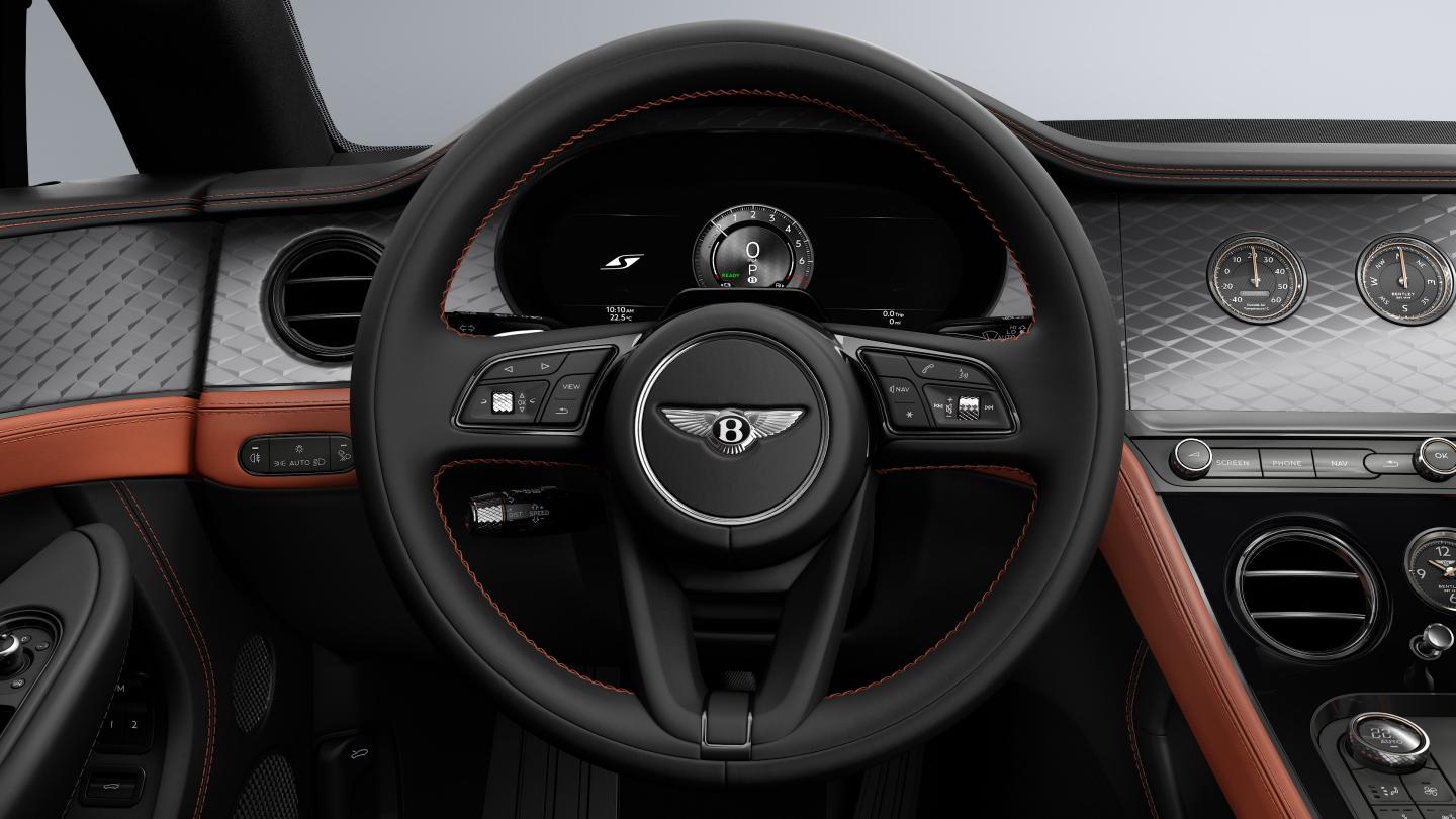 Driver’s view of the Bentley Continental GT S, showing the steering wheel with Diamond Brushed Dark Tint Aluminium veneer with Newmarket Tan and Beluga hide.