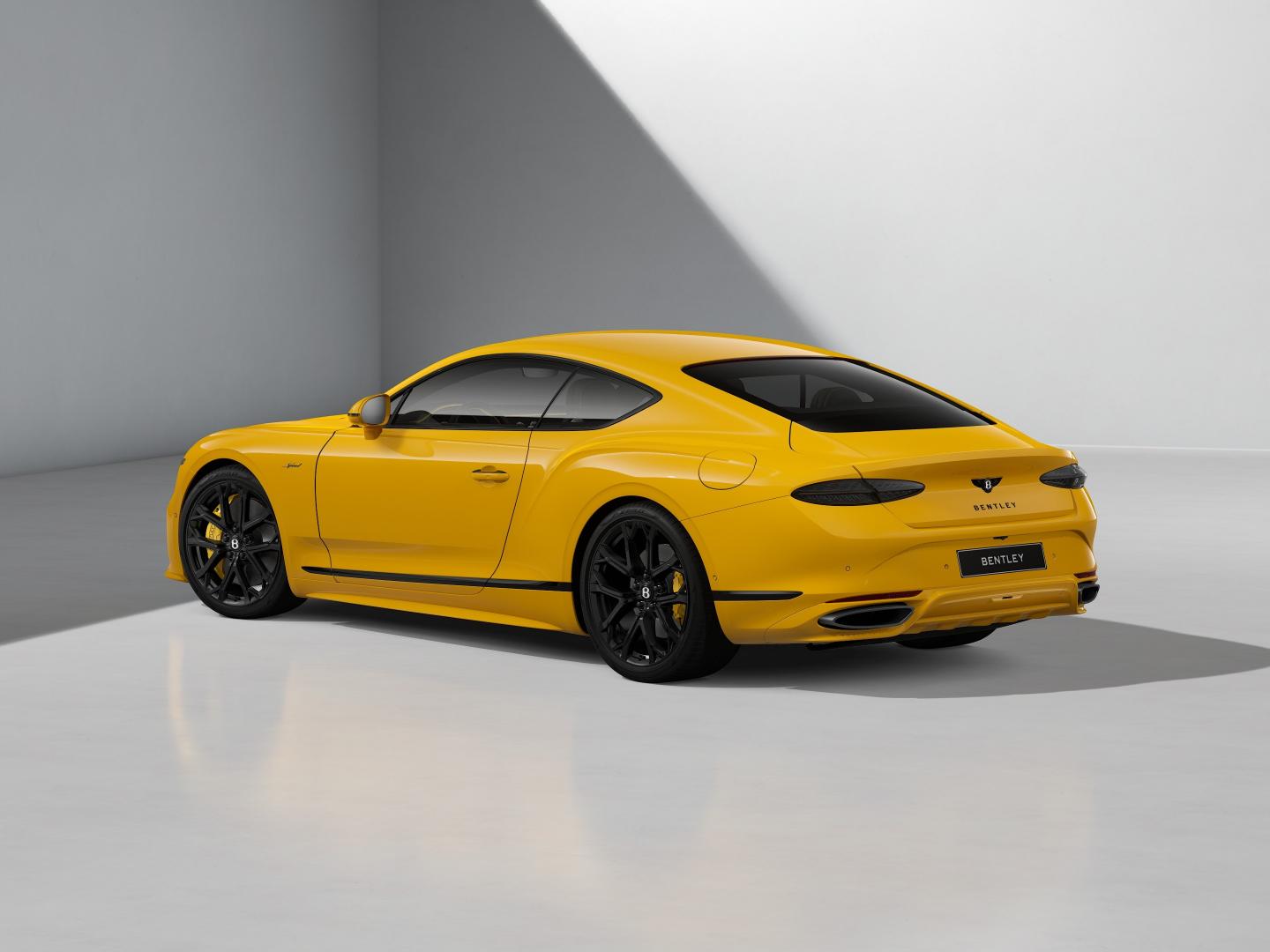 Rear three quarters shot of the Bentley Continental GT Speed in Monaco Yellow with 22" Ten Spoke Sports Wheel painted in black.
