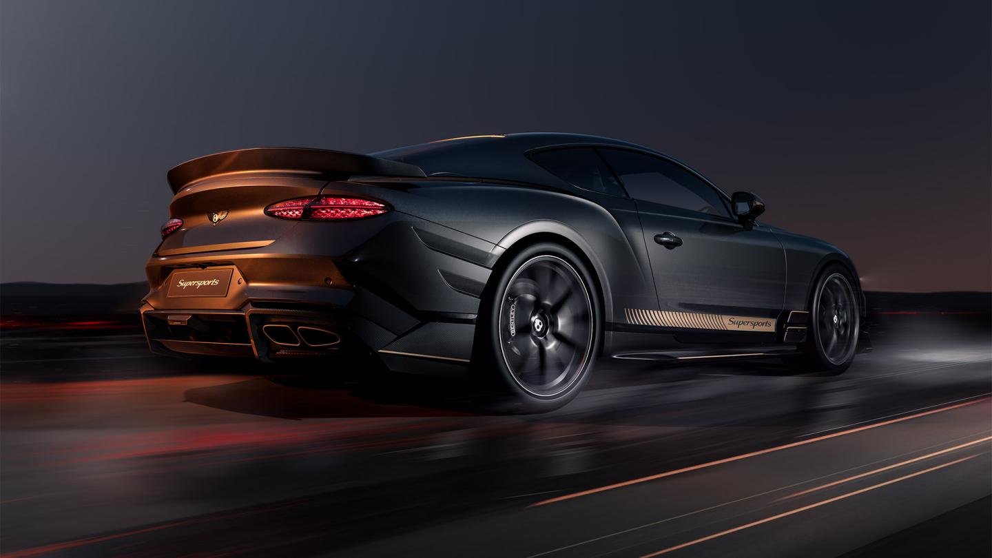 Rear three quarter of a Bentley Supersports in Antracite Satin driving dynamically on a runway