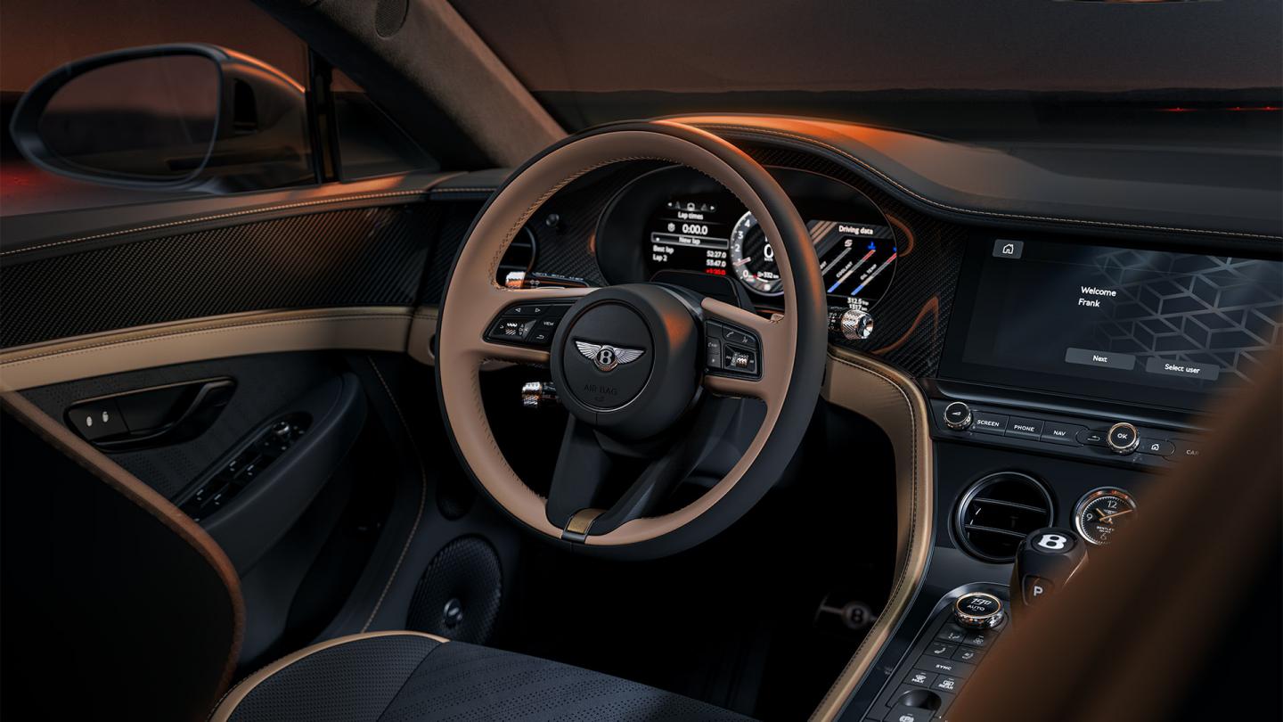 Close up of the drivers steering wheel and display in a Beluga Supersports cabin