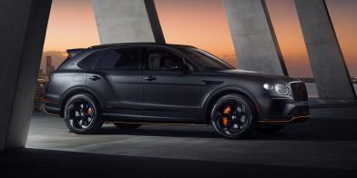 Light grey satin Bentley Bentayga S Black Edition, parked in an urban environment featuring 22 inch S directional wheel - Black Painted and Polished as well as Mandarin accents on the styling kit