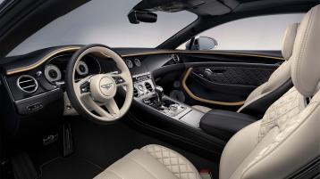 View over looking driver's seat of Bentley Continental GT Mulliner featuring Grand Black with Diamond Milled Console veneer contrasted by Linen Hide.