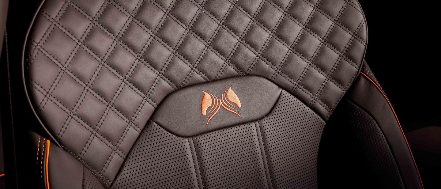 Bentley Bentayga Bentayga S's front seat in focus, featuring detailed Diamond quilt detailed stitching and Orange flame piping witch custom emblem.