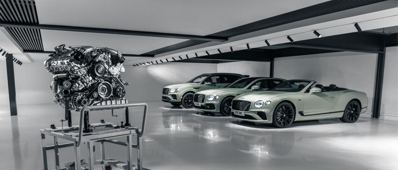 Side angled view of Bentley Continental GTC Speed Edition 12, Bentley Flying Spur Speed Edition 12 and Bentley Bentayga Speed Edition 12 parked side by side in Opalite colour, with Bentley 6.0 Litre W12 Twin Turbo Charged Engine in view.