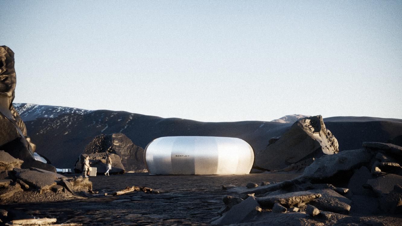 Futuristic architecture of enclosed metallic capsule featured in Bentley Dezeen design competion in Iceland, with rocky mountains in backdrop.
