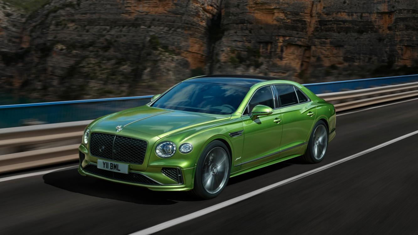 Bentley Flying Spur Azure in Topaz Blue Colour, side angled view featuring 2" Ten Spoke Wheels - Black Painted and Bright Machined and Chrome vertical vents at front, driving along sea side.