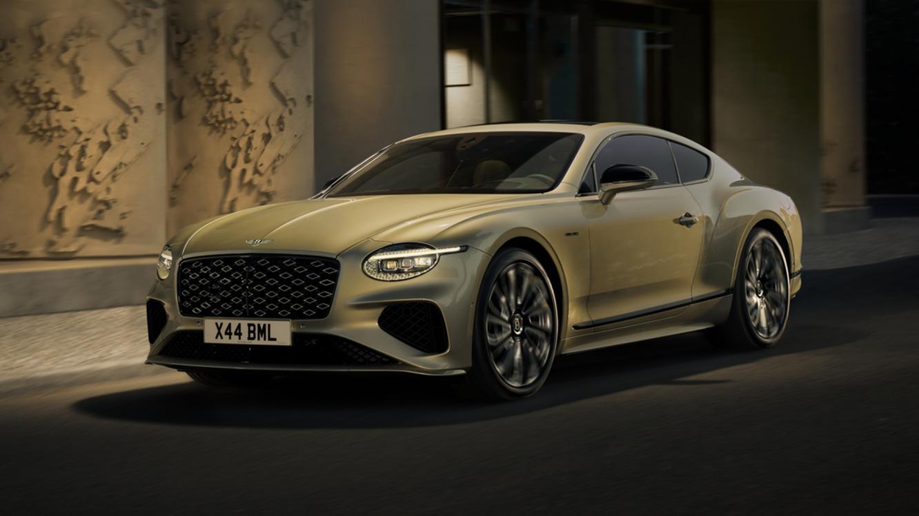 Front profile of the new hybrid Continental GTC Speed in Patina driving in an urban environment