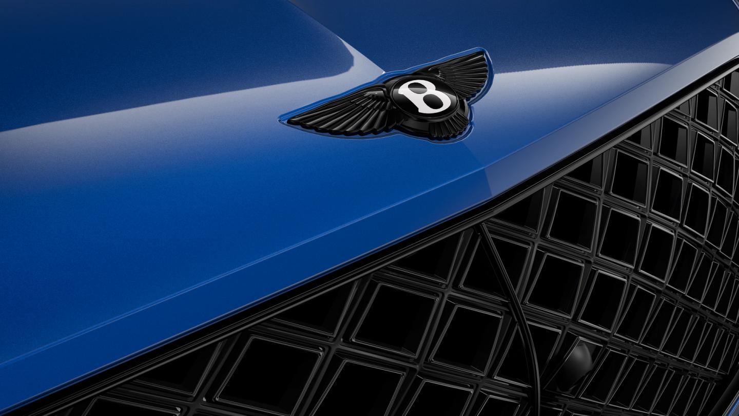 Bentley Bentayga Artenara Edition SUV in Sequin Blue paint and 22” Mulliner Gloss Black wheels badge close up