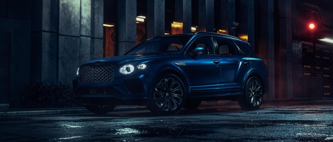 New Bentayga Speed in Snow Quartz by Mulliner exterior paint with the Bentayga Styling Specification and 23" Directional Wheels driving on sand dunes.