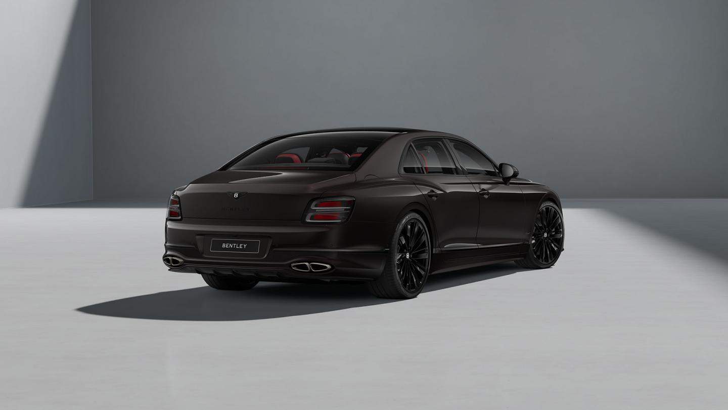 Rear three-quarter shot of the Bentley Flying Spur Speed in Black Velvet with Blackline Specification and dark exterior detailing.